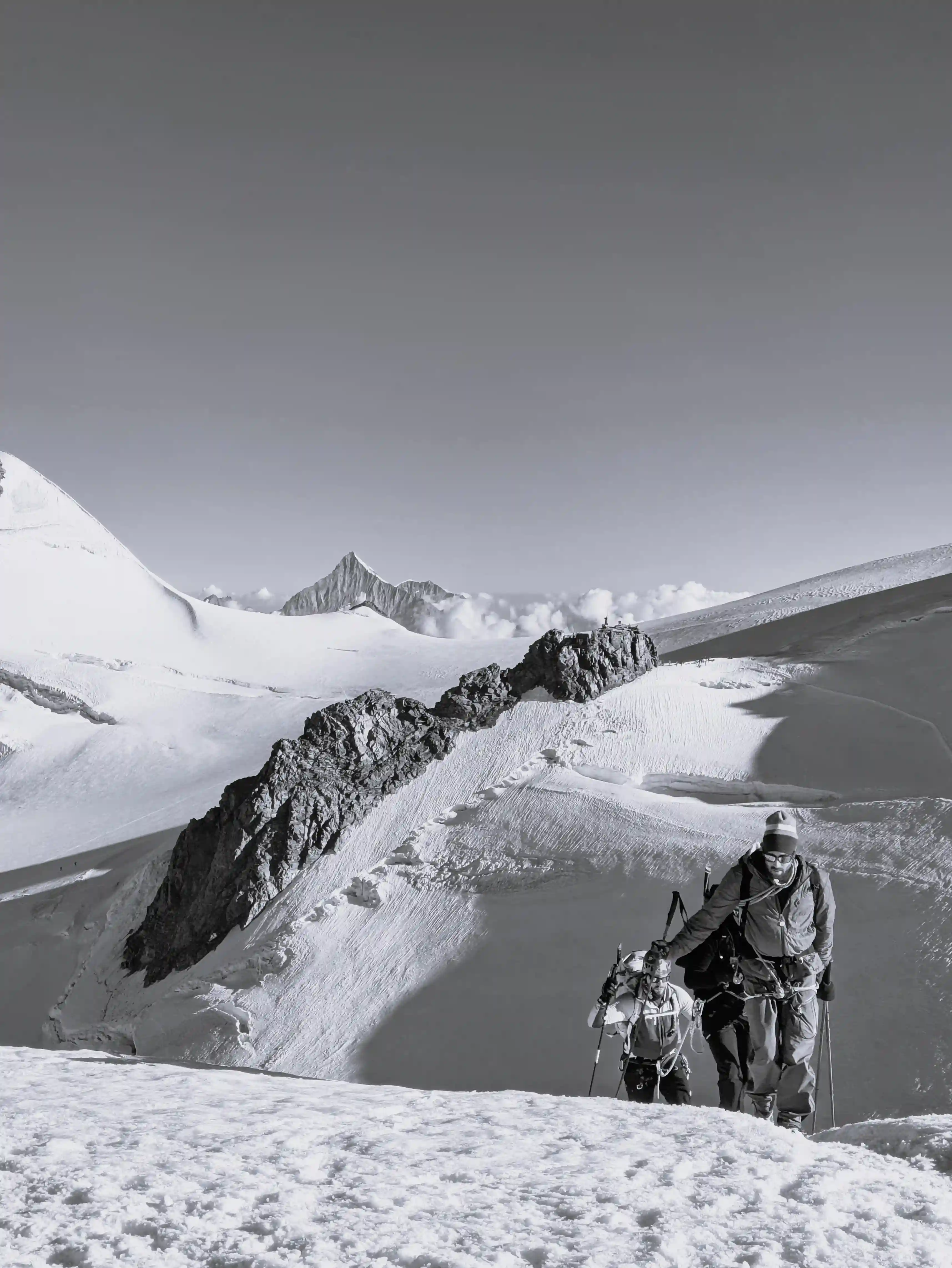 Une cordée progressant ensemble sur une arête neigeuse